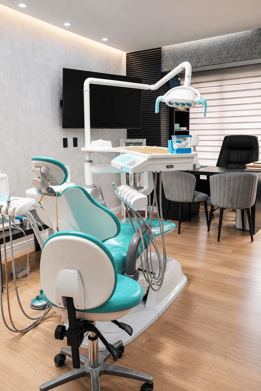 Consultorio de PAUDENT con unidad dental turquesa y área de escritorio.