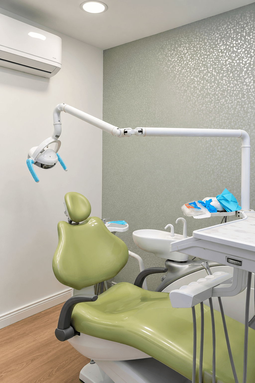 Unidad dental verde con lámpara y equipo de atención en un consultorio de PAUDENT.
