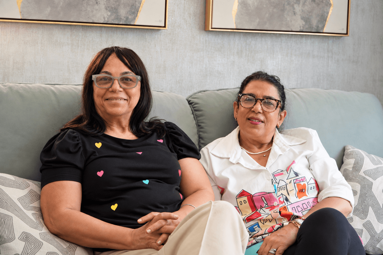 Dos pacientes sentadas juntas en el sofá de la sala de espera de PAUDENT.